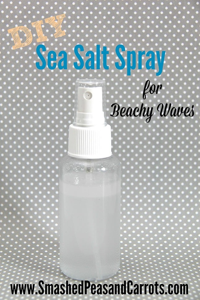 Clear spray bottle filled with homemade sea salt spray for beachy waves on a plain gray background with title text