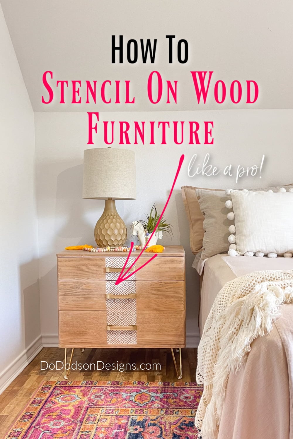 Natural wood nightstand with gold hairpin legs and a white Greek key stencil on the drawers, beside a bed with title text