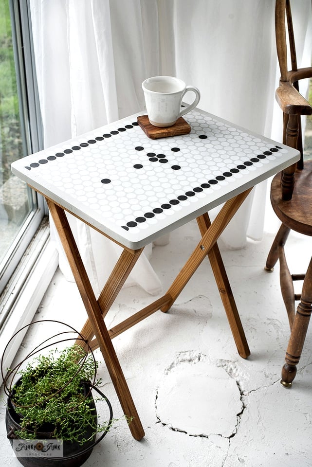 Stenciled Penny Tile TV Tray | Thrift Store Flip White folding TV tray tiled in white penny rounds with black dot borders, wood legs, a mug on a coaster and a thyme pot