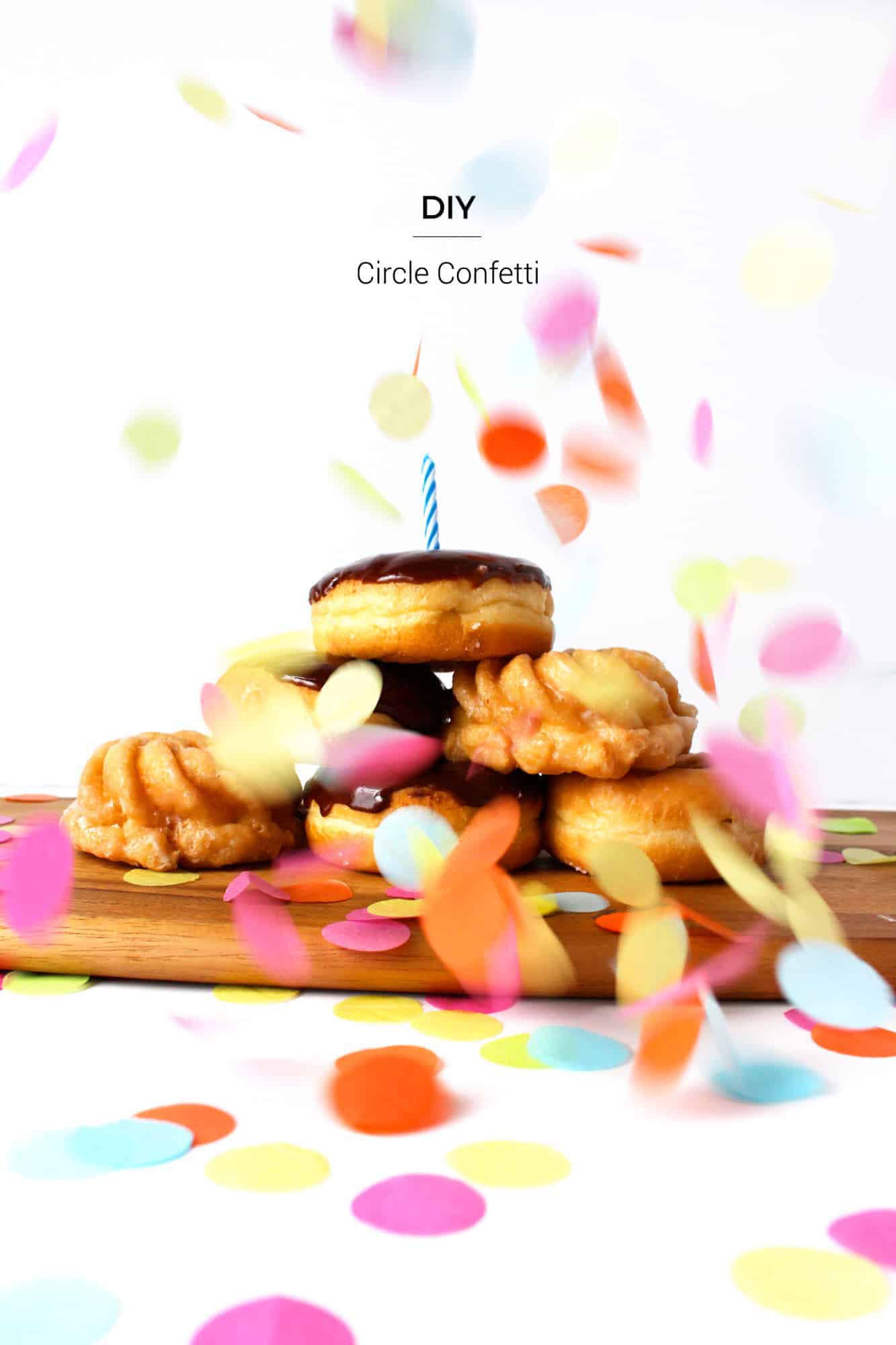 Tissue Paper Circle Confetti | DIY Party Decorations Idea Pastel and bright tissue paper circle confetti falling over a stack of donuts with a birthday candle