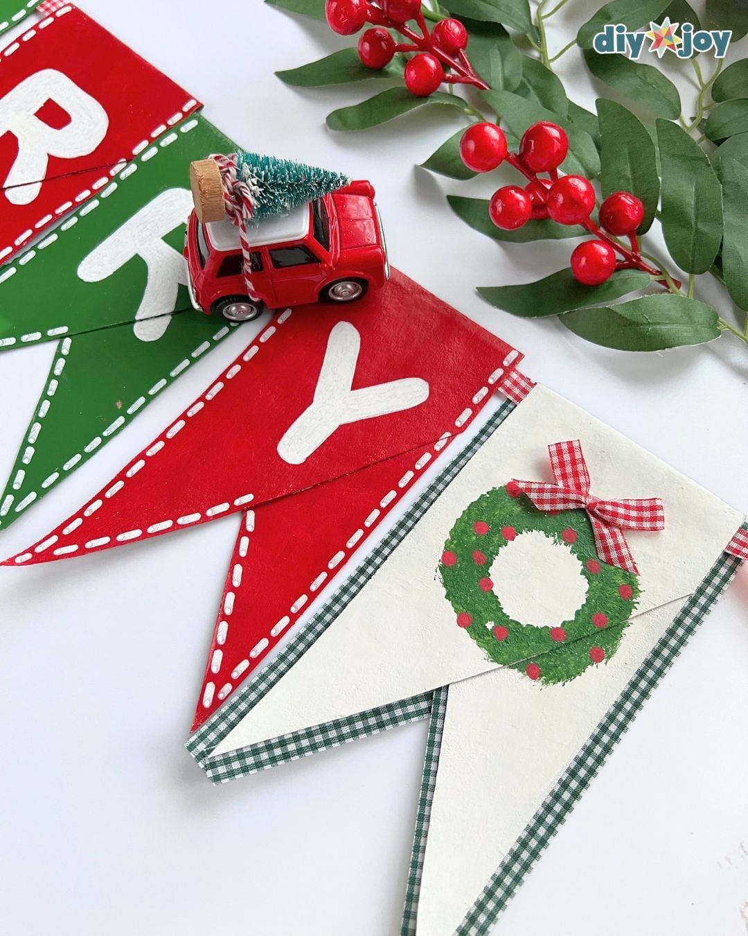 Close-up of the Merry Christmas letters and wreath pennant on a toilet paper roll Christmas banner made from cardboard tubes