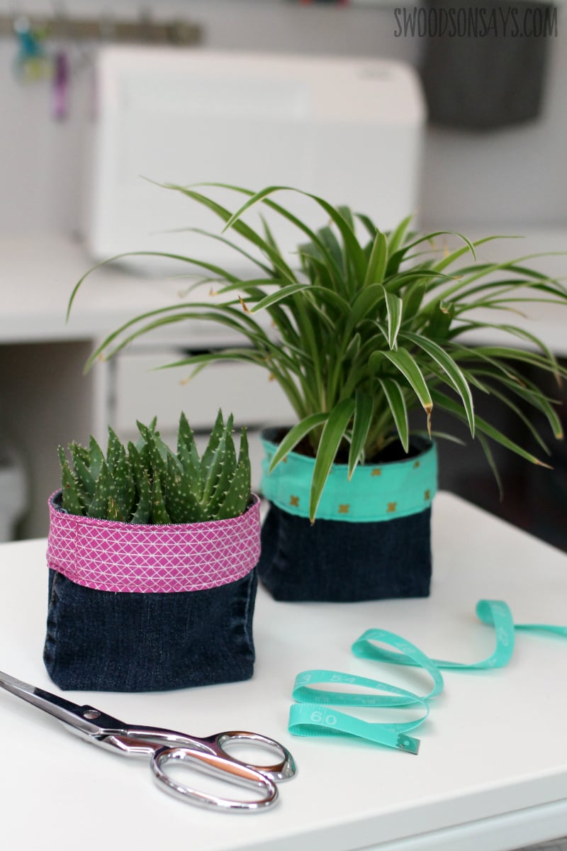 Upcycled Denim Plant Pot Cozies Two denim plant pot covers made from jean legs with pink and teal print fabric bands, holding a succulent and spider plant