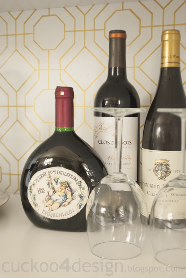 DIY bamboo graphic pattern, a white cabinet with a gold trellis patterned back panel holding wine glasses and flowers
