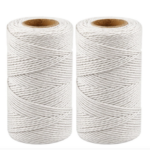 Two spools of white cotton twine string used to string the fabric candies and wooden beads into a DIY Christmas garland