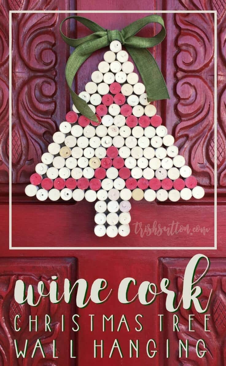 Wine cork Christmas tree wall hanging of white and pink painted cork halves with a green bow on a red carved door